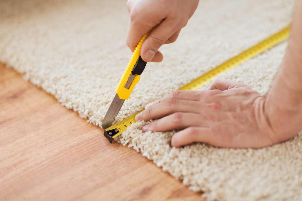 precisely measuring and cutting carpet in new floor installation